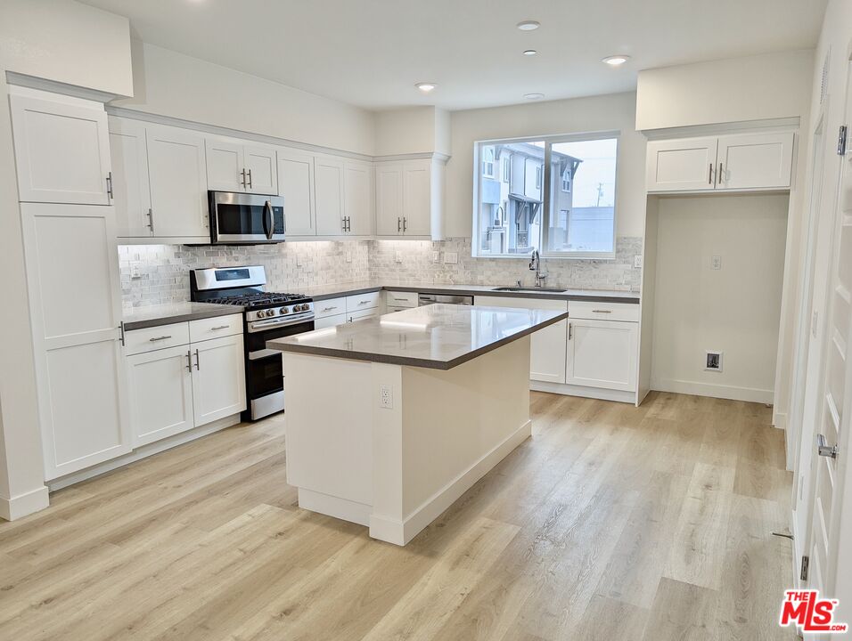 7107 Ryder Ln. Gardena, CA 90248 - Photo 1 of 11 a kitchen with stainless steel appliances granite countertop a stove a sink and a refrigerator