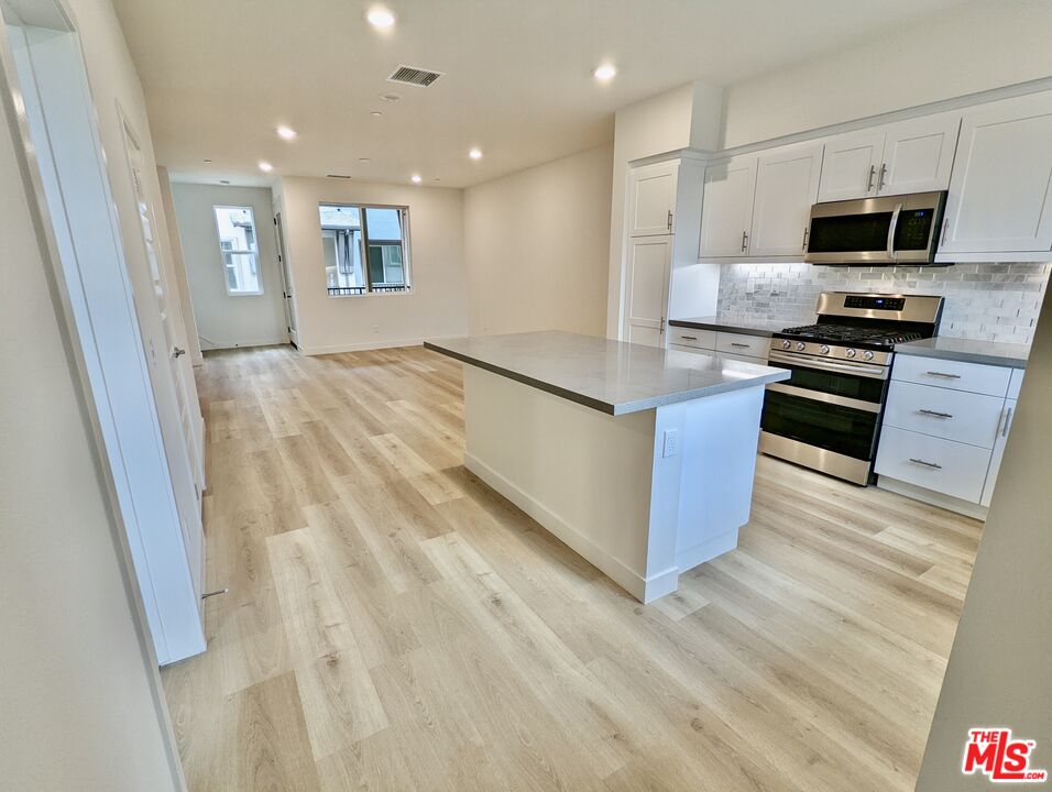 7107 Ryder Ln. Gardena, CA 90248 - Photo 2 of 11 a kitchen with stainless steel appliances granite countertop a refrigerator a stove top oven a sink and dishwasher