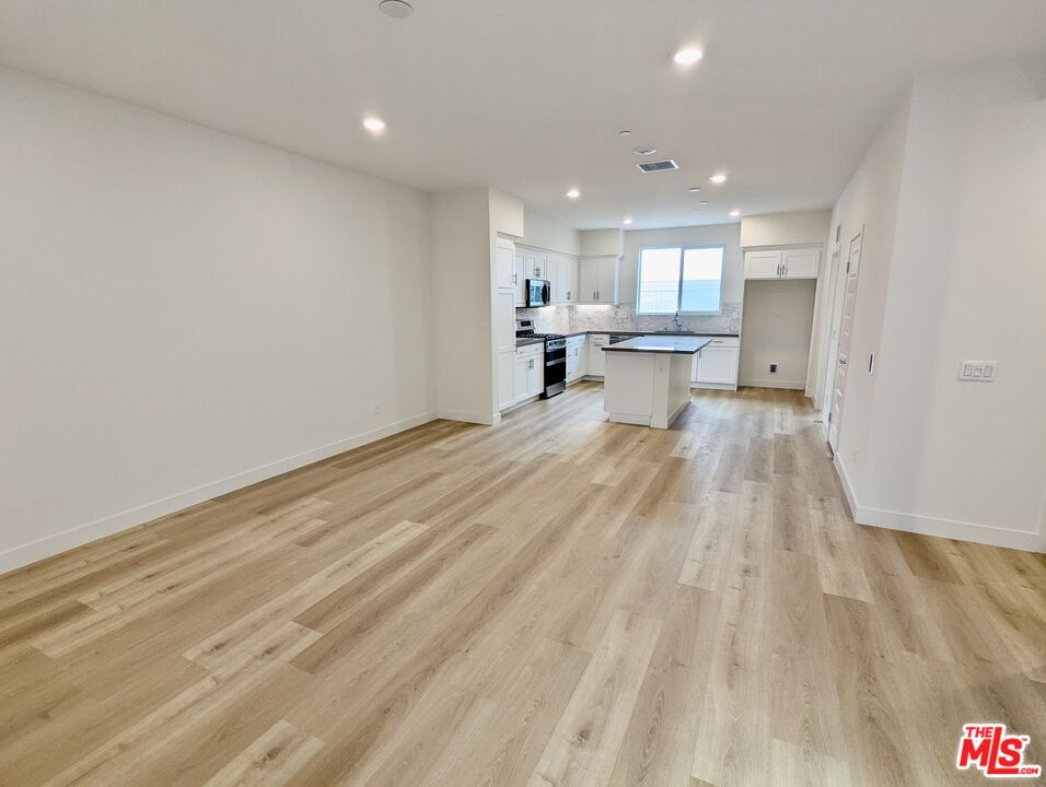 7107 Ryder Ln. Gardena, CA 90248 - Photo 3 of 11 a view of a kitchen with kitchen island a sink wooden floor and a counter top space