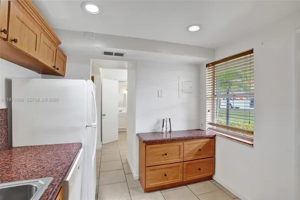 a bathroom with a granite countertop sink a mirror and a shower