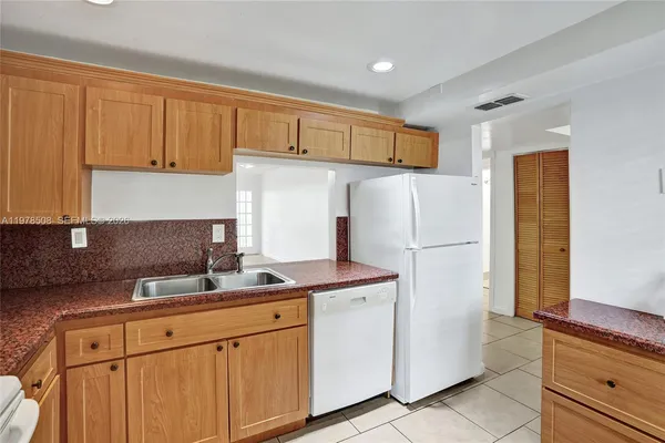 a kitchen with stainless steel appliances granite countertop a refrigerator sink and cabinets