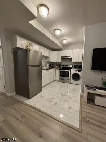 a kitchen with kitchen island a counter top space stainless steel appliances and cabinets