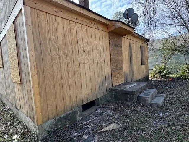 a backyard of a house with chairs and wooden fence