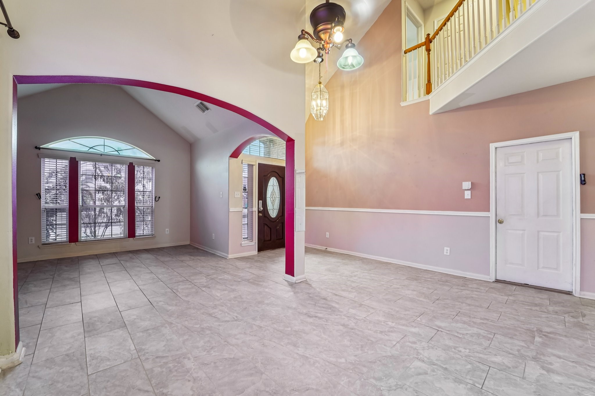 3818 Ridge Canyon Road Baytown, TX 77521 - Photo 12 of 42 This spacious living area features high ceilings and abundant natural light. It includes elegant tile flooring, an arched entryway, and a stylish chandelier. The room opens to a second level with a railing, providing an open and airy feel.