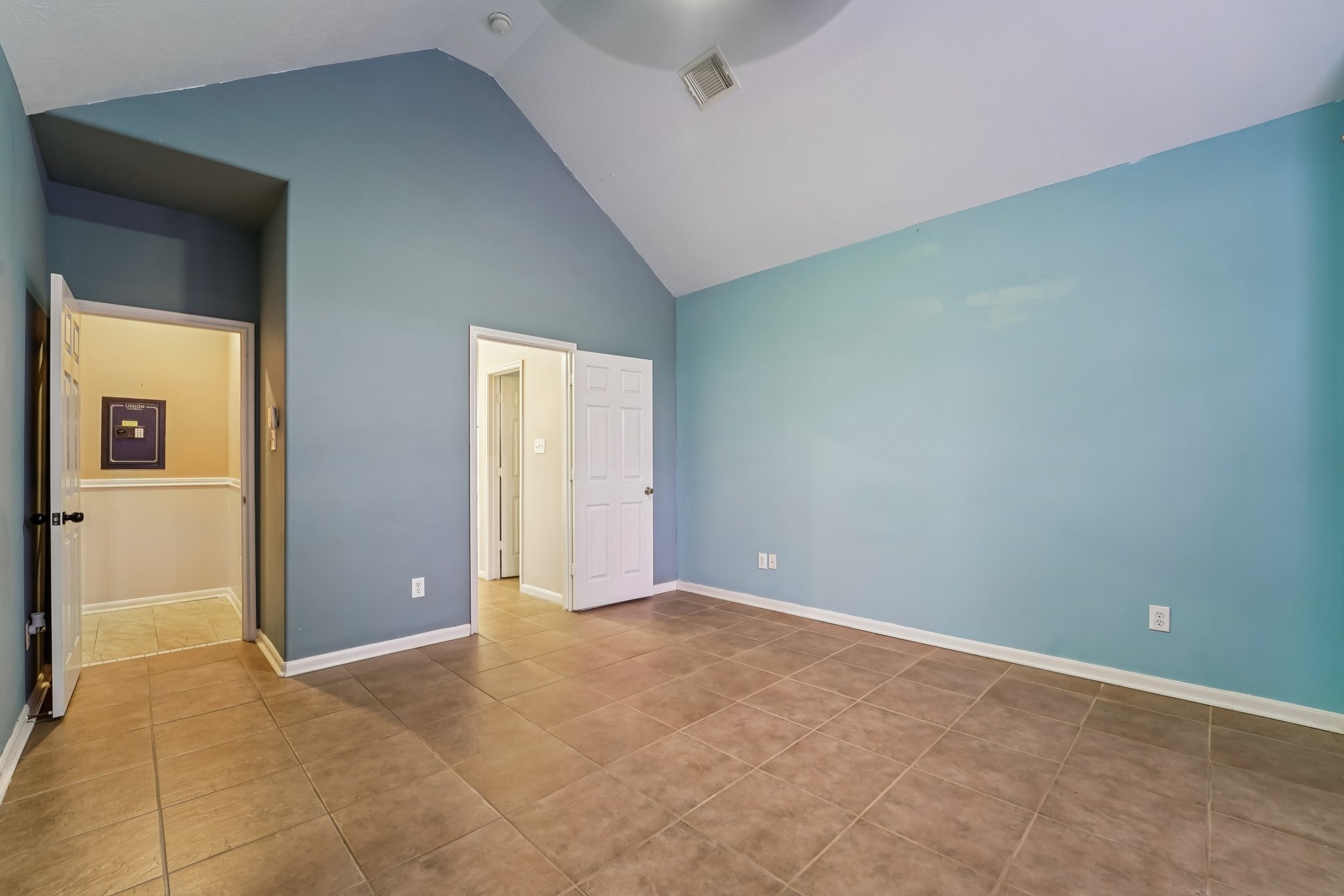 3818 Ridge Canyon Road Baytown, TX 77521 - Photo 25 of 42 This room features a spacious layout with high ceilings, light blue walls, and tile flooring. It includes multiple doorways leading to other areas of the home, enhancing accessibility and flow.