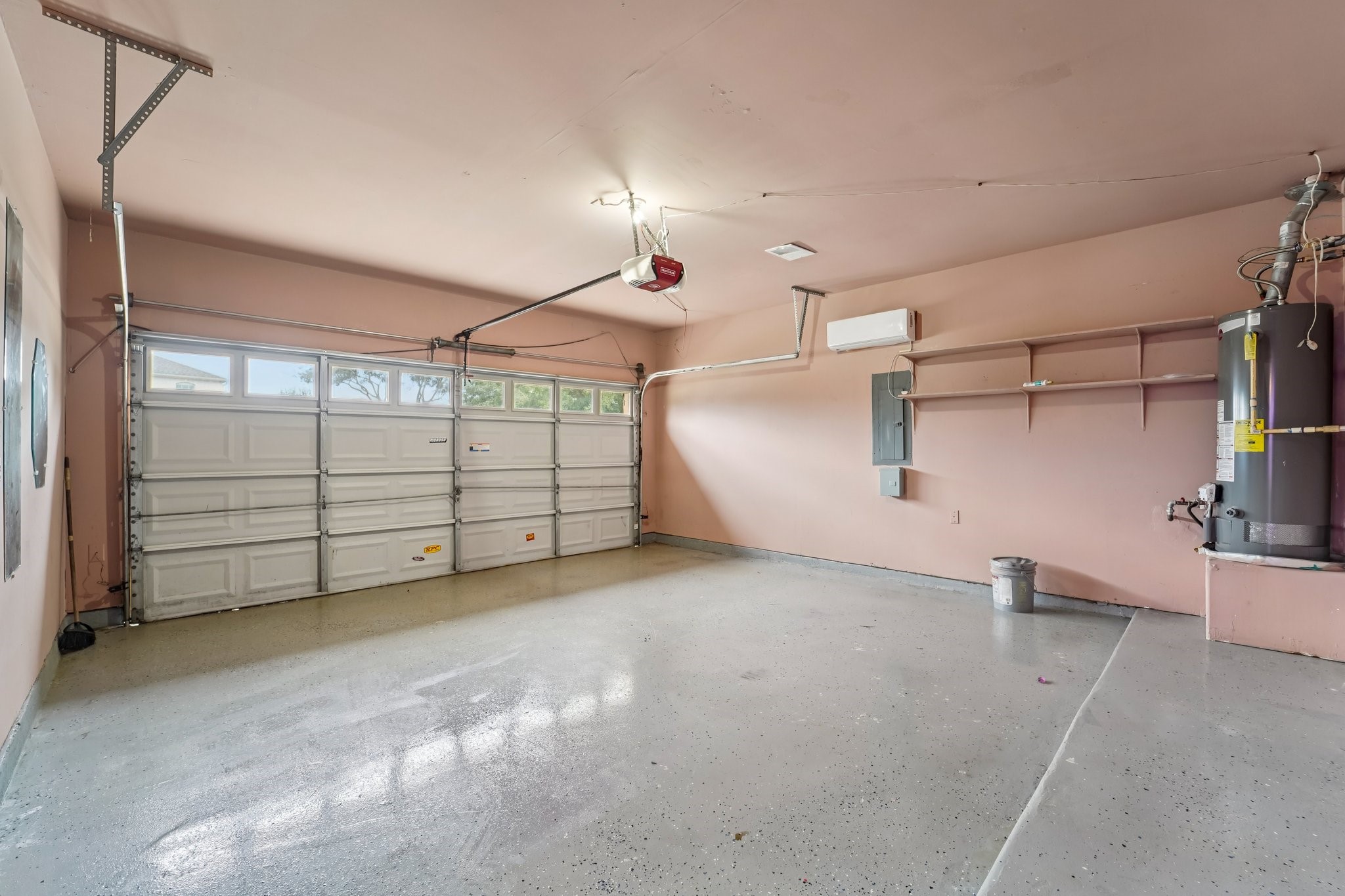 3818 Ridge Canyon Road Baytown, TX 77521 - Photo 3 of 42 This spacious garage features a double-door entrance, polished concrete floors, built-in shelving, and a water heater. It’s well-lit and includes a wall-mounted HVAC unit for climate control. Ideal for parking and additional storage.