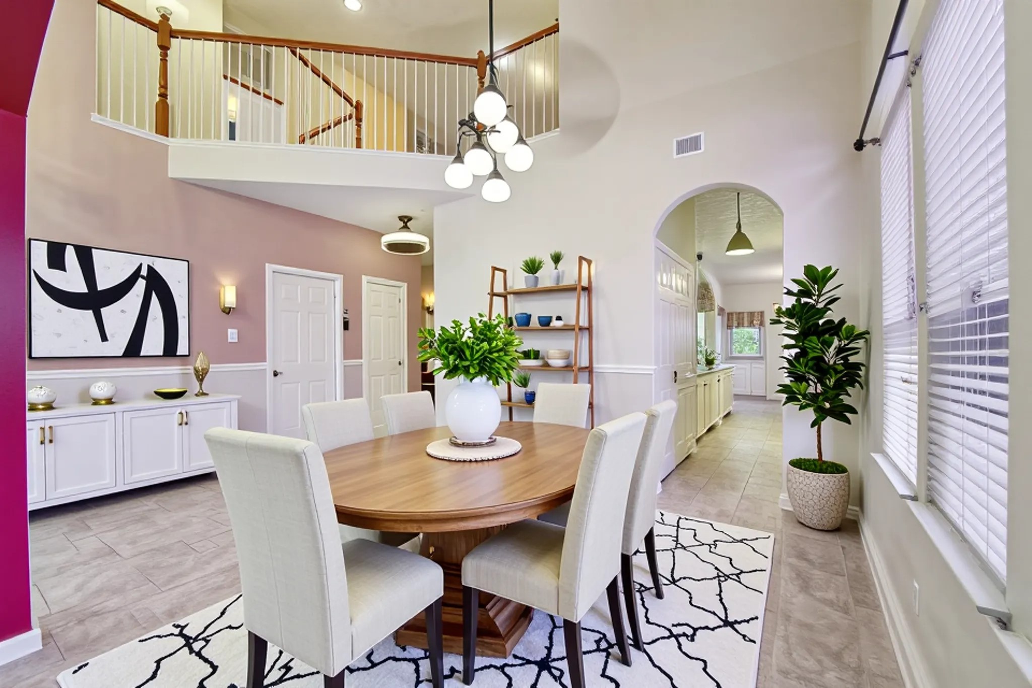 3818 Ridge Canyon Road Baytown, TX 77521 - Photo 9 of 42 This home features a bright, open living space with high ceilings and a second-floor balcony. The tile flooring complements the soft wall colors, and large windows provide ample natural light. An arched entryway leads to the kitchen, offering a seamless flow for entertaining.