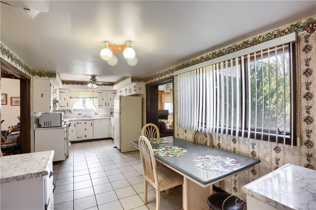 401 West Jefferson Road Butler, PA 16002 - Photo 9 of 22 a open kitchen with stainless steel appliances granite countertop a stove a refrigerator a sink dishwasher with a dining table and chairs with wooden floor
