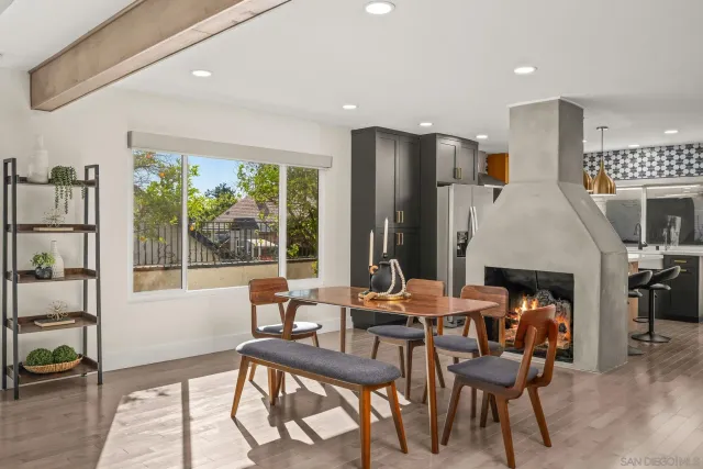 a dining room with furniture a fireplace and wooden floor
