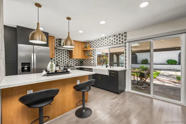 a kitchen with stainless steel appliances granite countertop sink stove and refrigerator
