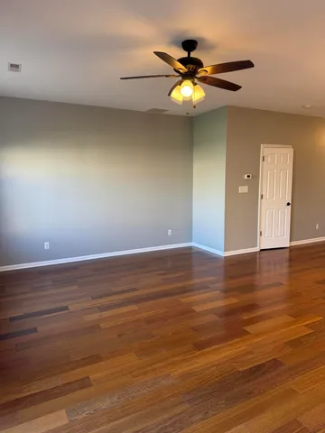 a view of a room with wooden floor and window