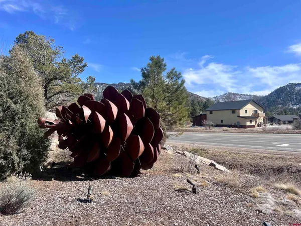 a view of a house with a yard and tree in the background