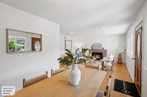 a dining room with furniture and a potted plant