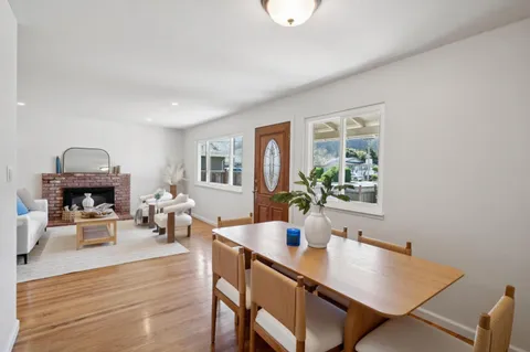 a view of a dining room with furniture a potted plant and wooden floor