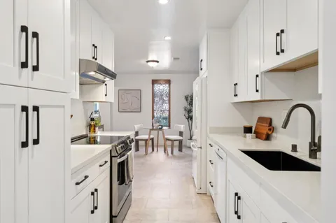 a kitchen with stainless steel appliances a sink a stove a refrigerator and cabinets