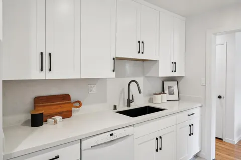 a kitchen with white cabinets and white appliances