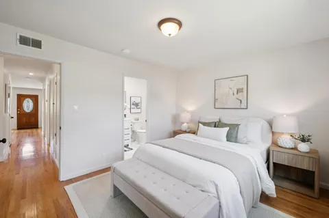 a bedroom with a bed and wooden floor