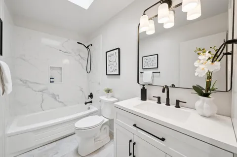 a bathroom with a sink a toilet and a mirror