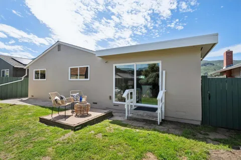a backyard of a house with table and chairs