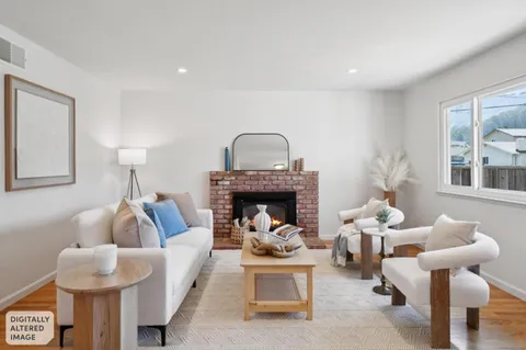 a living room with furniture a fireplace and a chandelier