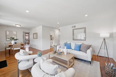 a living room with furniture and a wooden floor