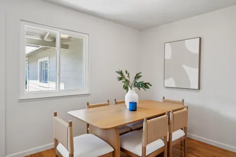 a dining room with furniture and wooden floor
