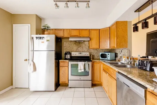 a kitchen with a refrigerator a stove top oven a sink and dishwasher