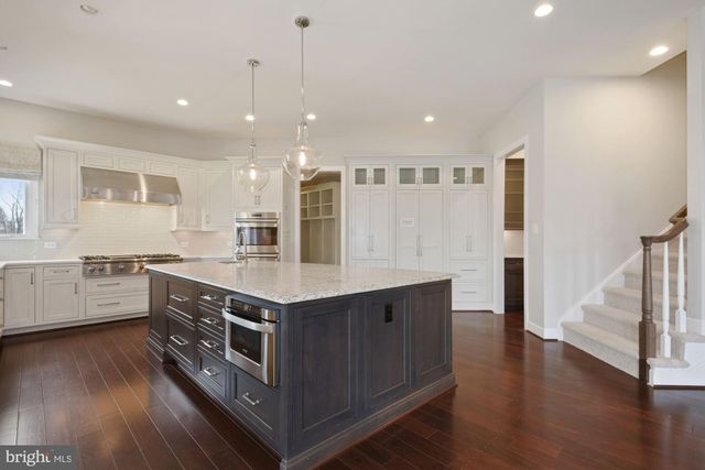 a view of kitchen with wooden floor and electronic appliances