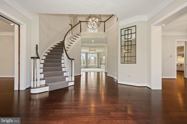 a view of an empty room with wooden floor fireplace and a window