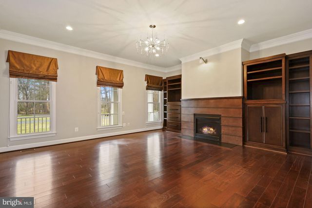 a view of a livingroom with a fireplace wooden closet and windows