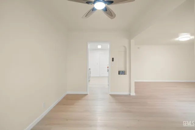 a view of an empty room with a chandelier fan