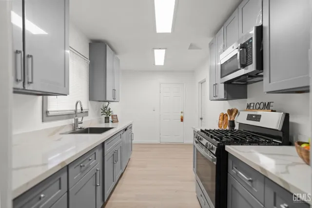 a kitchen with stainless steel appliances granite countertop a sink stove and cabinets