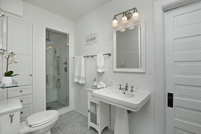 a bathroom with a sink a toilet and shower