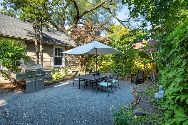 a view of a patio with table and chairs under an umbrella