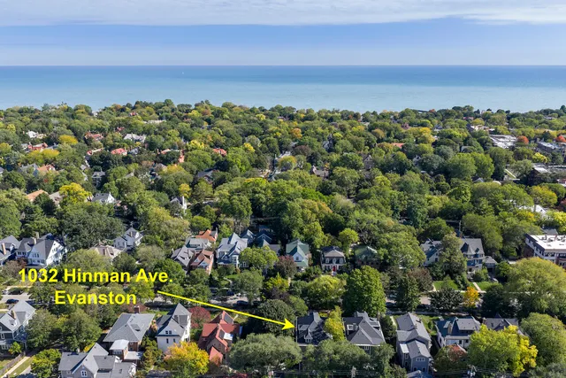 an aerial view of a houses with a yard and mountain view in back