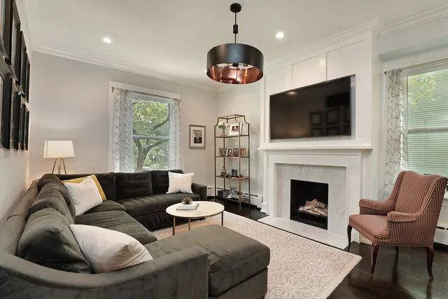 a living room with furniture a flat screen tv and a fireplace