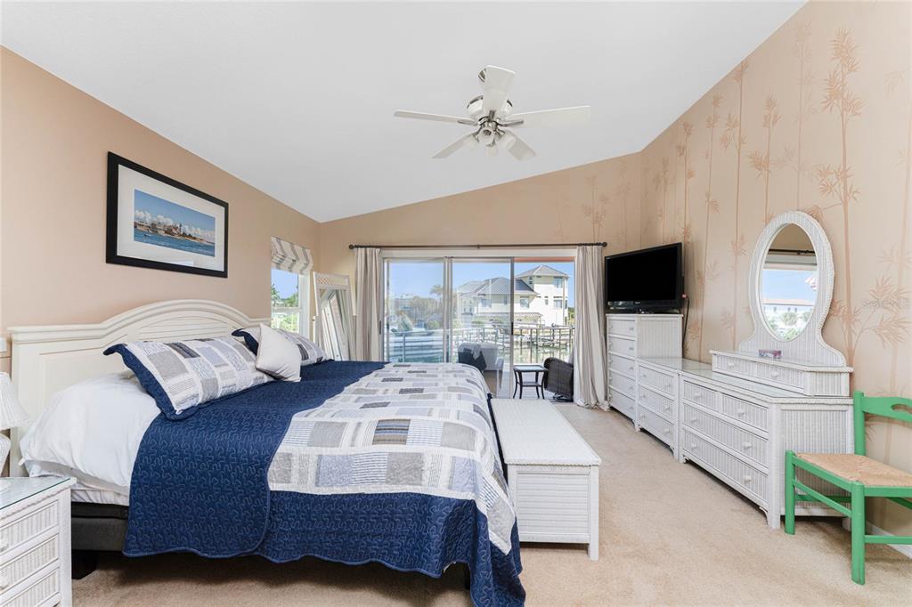 2805 North Beach Road, Unit B Englewood, FL 34223 - Photo 31 of 86 a bedroom with a bed a mirror on dresser and a flat screen tv