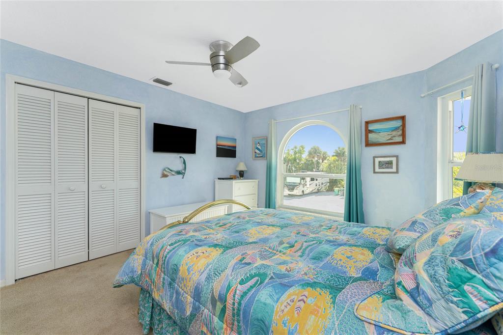 2805 North Beach Road, Unit B Englewood, FL 34223 - Photo 46 of 86 a bedroom with a bed and a flat tv screen on dresser