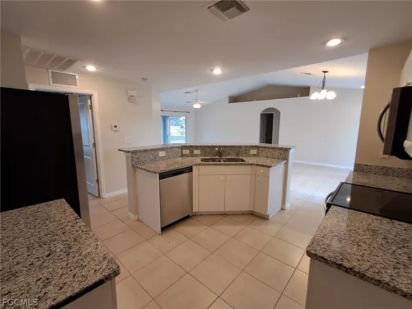 a kitchen with stainless steel appliances granite countertop a stove a sink and a refrigerator