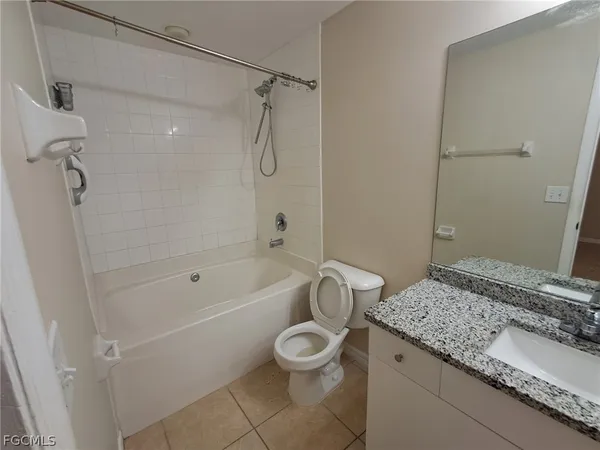 a bathroom with a granite countertop sink a toilet and a bathtub