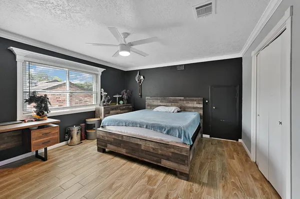 a bedroom with a bed and wooden floor