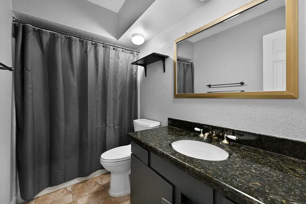 a bathroom with a granite countertop sink and a mirror
