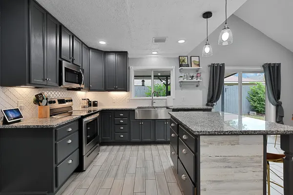 a kitchen with stainless steel appliances granite countertop counter space a sink cabinets and wooden floor