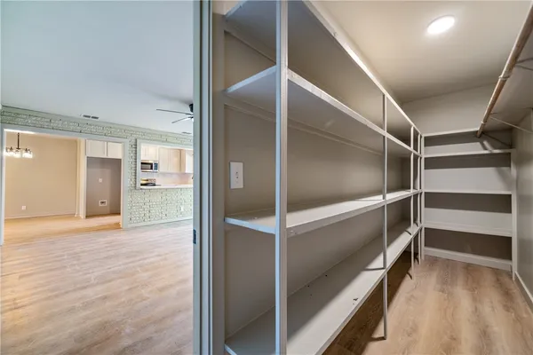 a view of an empty walk in closet and a bathroom