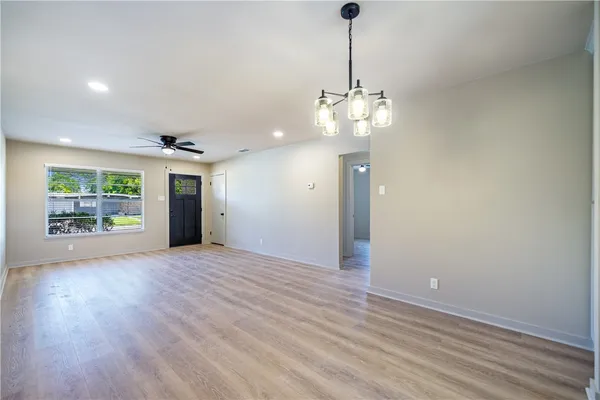 a view of an empty room with window and wooden floor