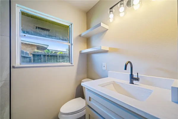 a bathroom with a sink a toilet and mirror