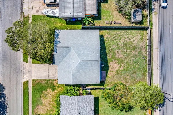 an aerial view of a house with a yard and large trees
