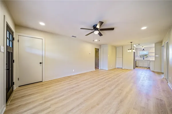 a view of a livingroom with a ceiling fan wooden floor and a ceiling fan