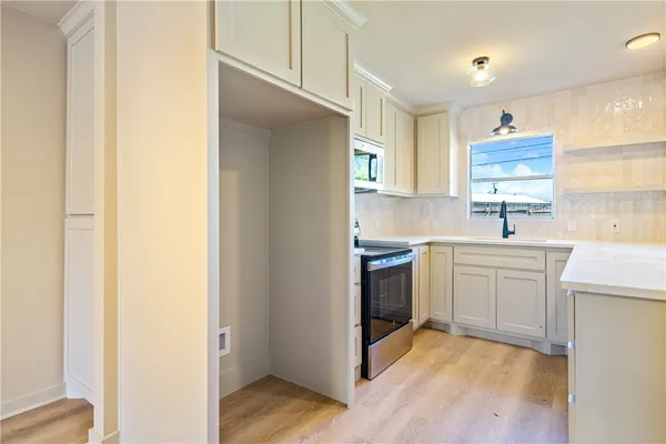 a kitchen with a sink cabinets stainless steel appliances and a window