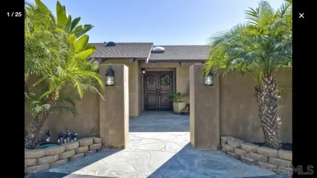 a view of a hallway with potted plants in front of door